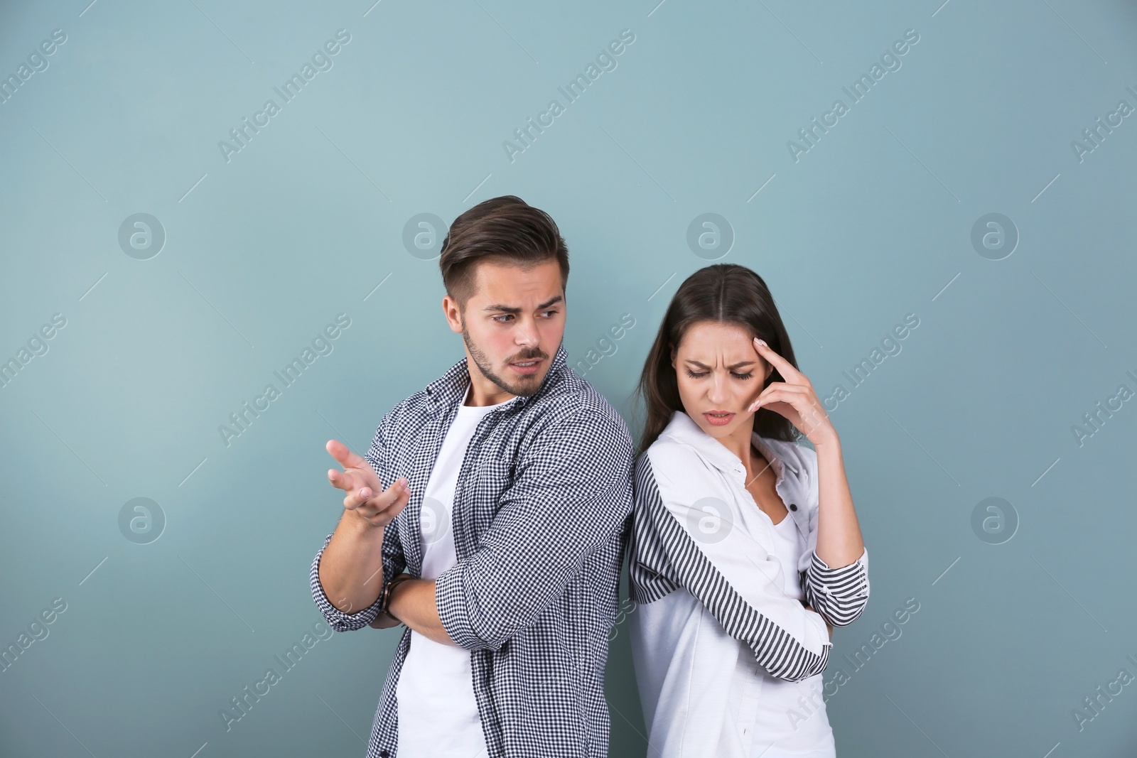 Photo of Upset young couple on color background. Relationship problems