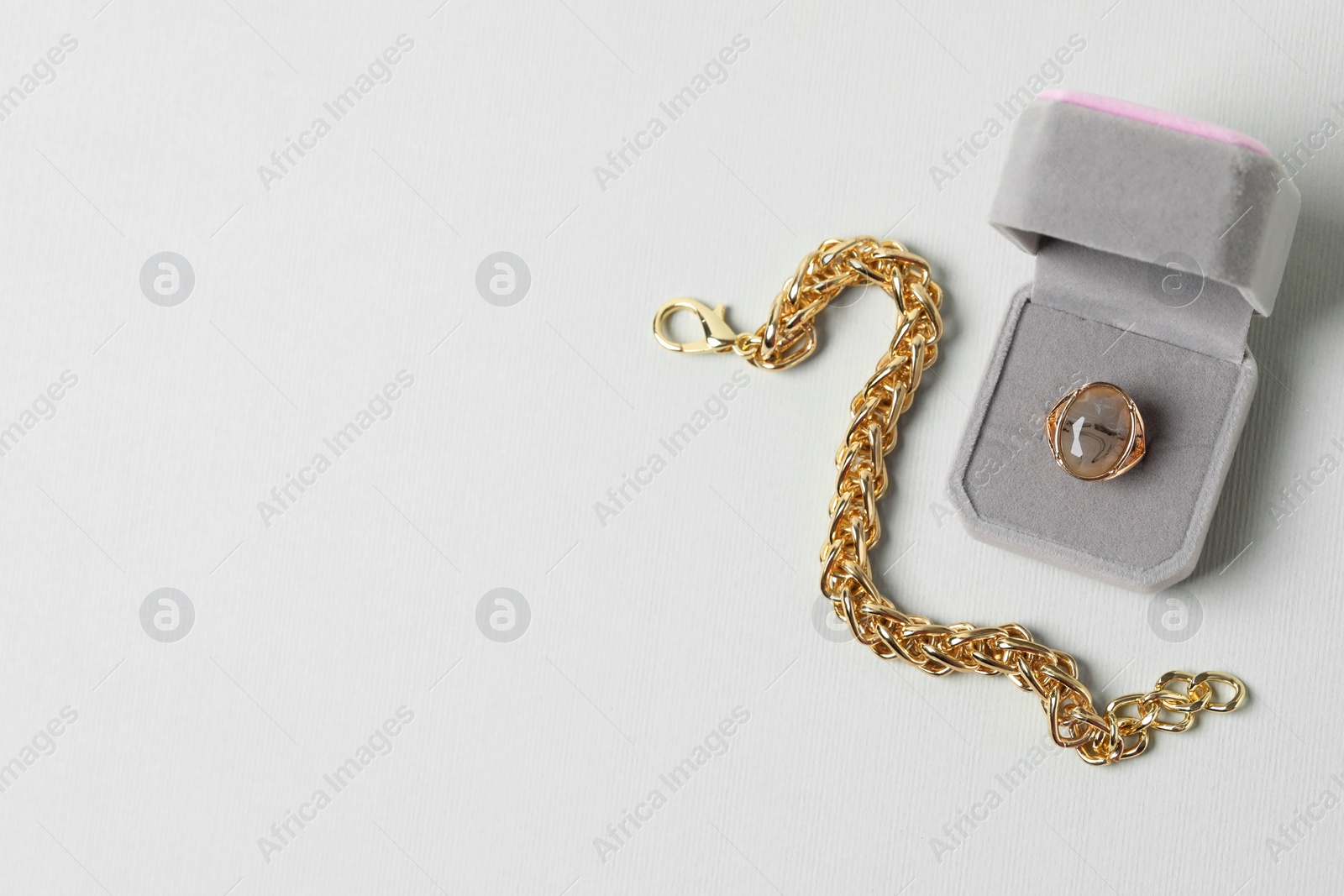 Photo of Jewelry box with ring and bracelet on light background, flat lay. Space for text