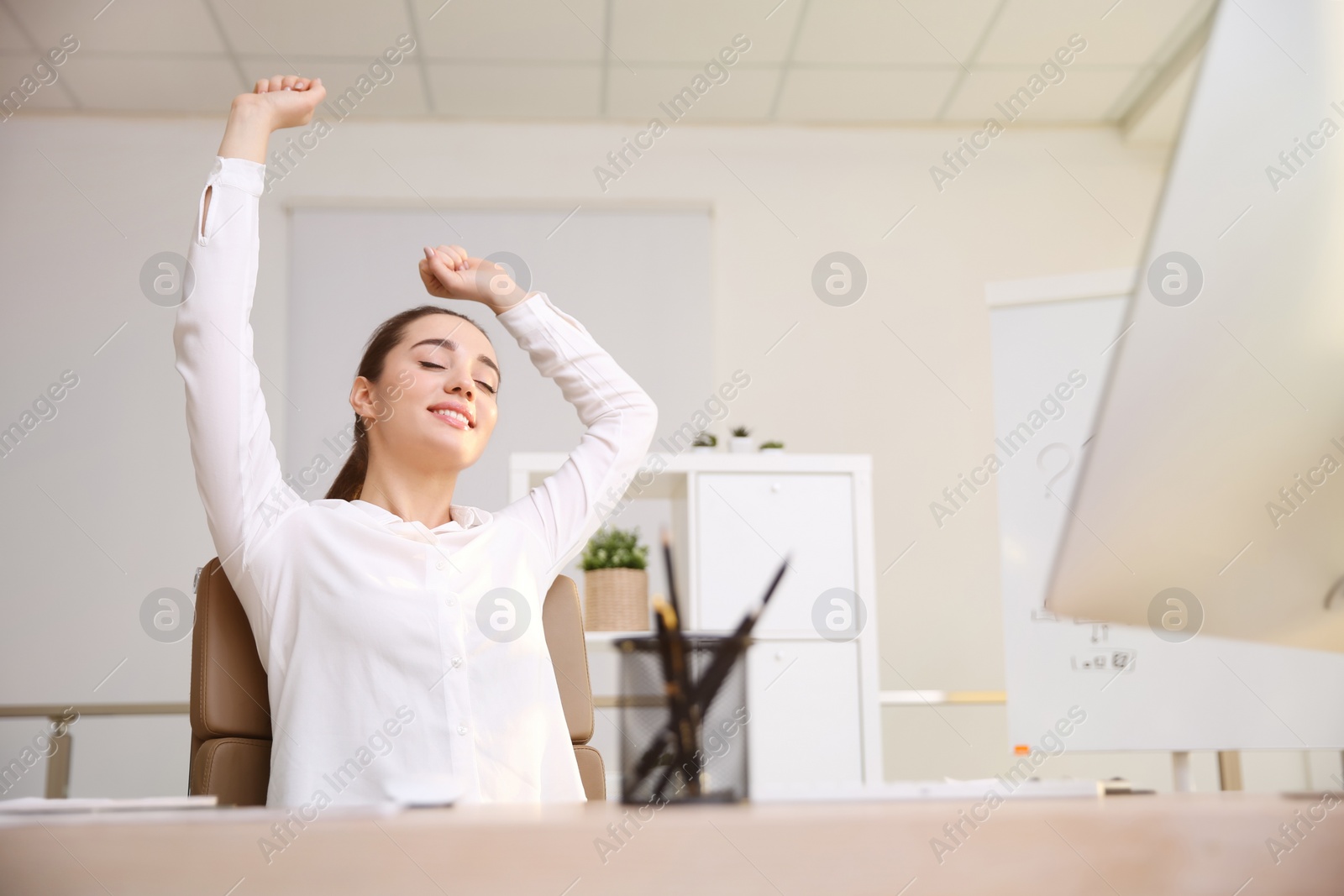 Photo of Young woman relaxing in office chair at workplace