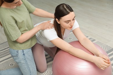 Doula massaging pregnant woman at home. Preparation for child birth