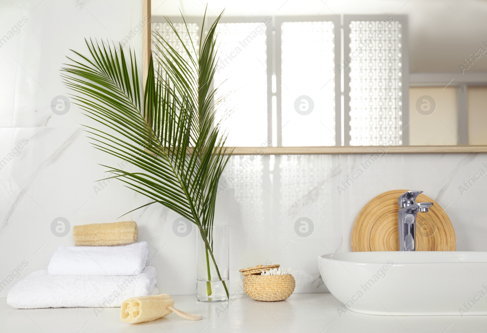 Photo of Tropical palm leaves in stylish bathroom interior