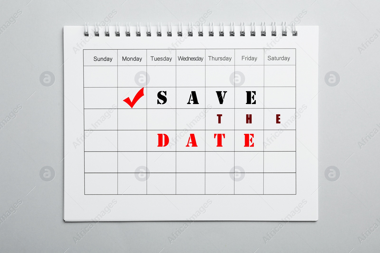 Image of Blank calendar with phrase SAVE THE DATE on light grey background, top view