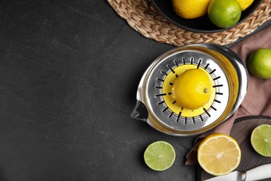 Squeezer, fresh lemons and limes on black table, flat lay. Space for text