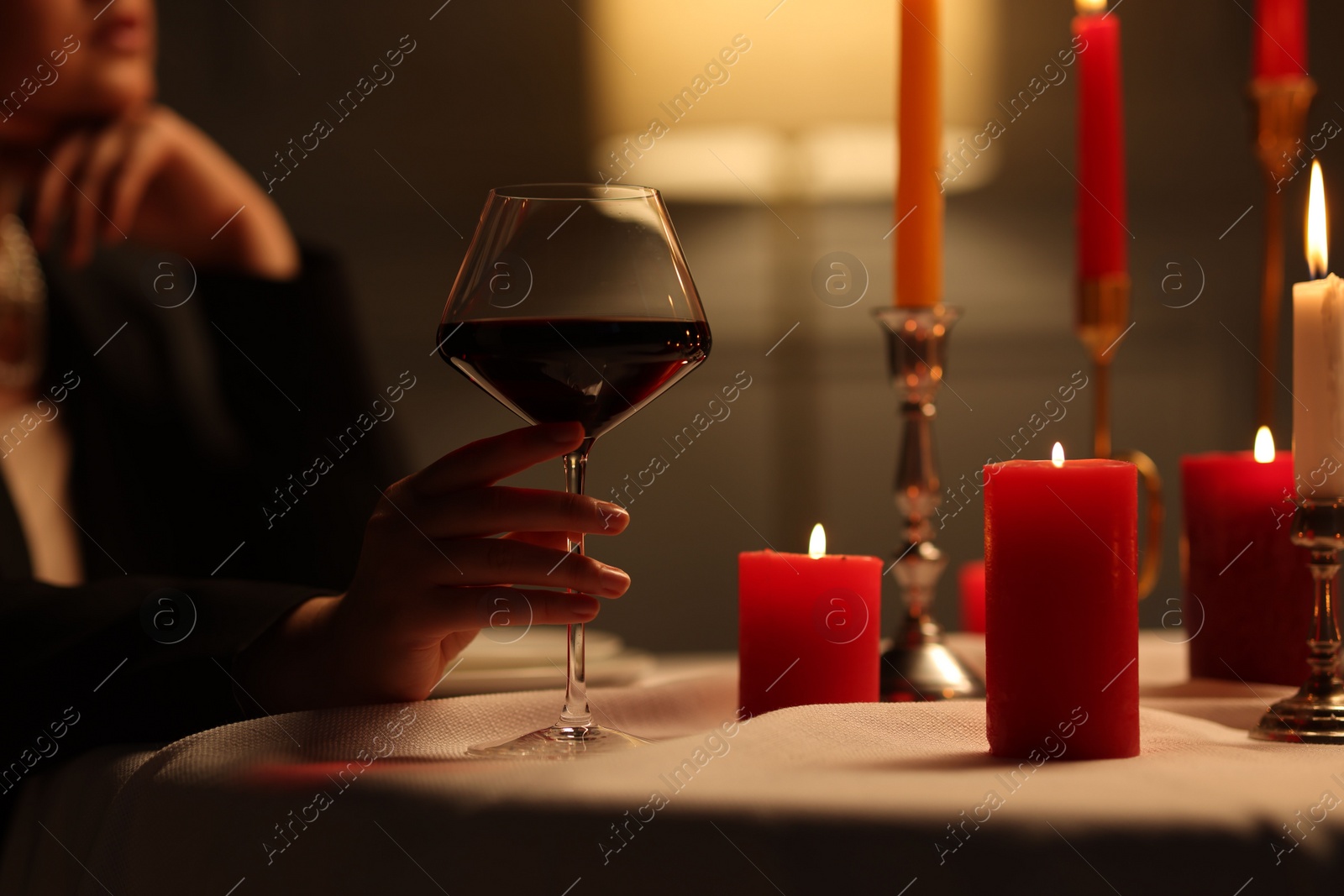 Photo of Beautiful young woman with glass of wine at table in restaurant, closeup