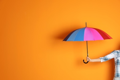 Photo of Woman holding beautiful umbrella on color background with space for design