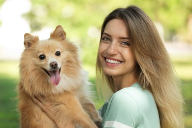 Photo of Young woman with her cute dog in park on sunny day