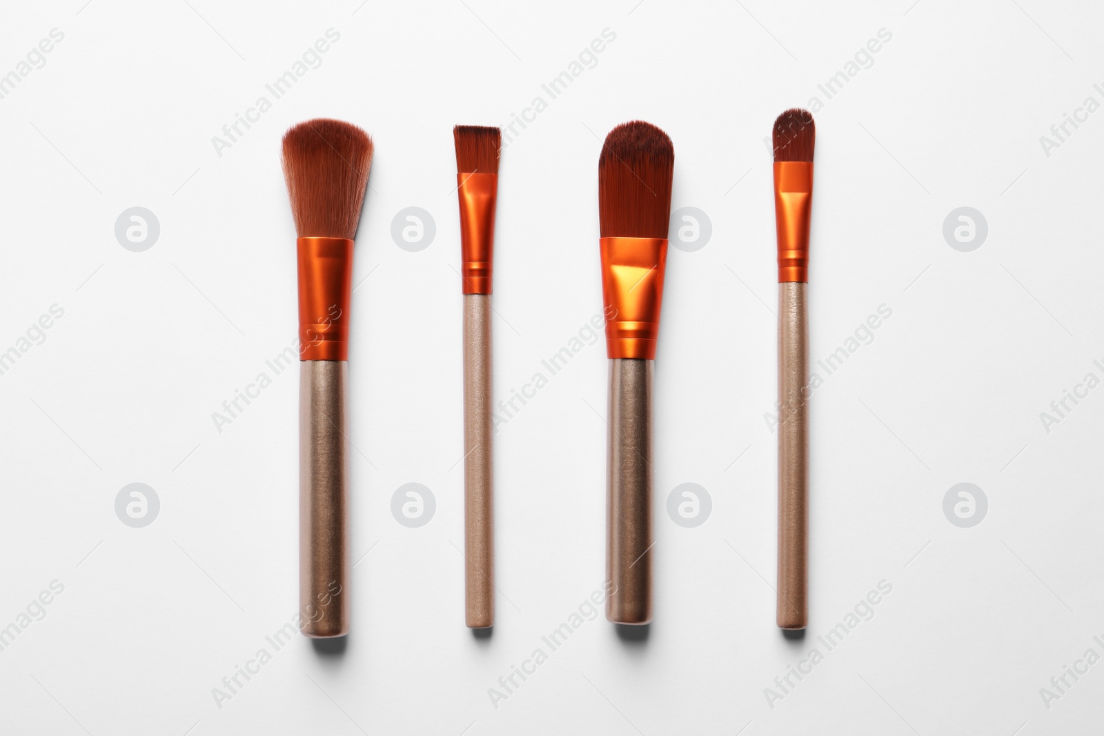 Photo of Different makeup brushes on white background, flat lay