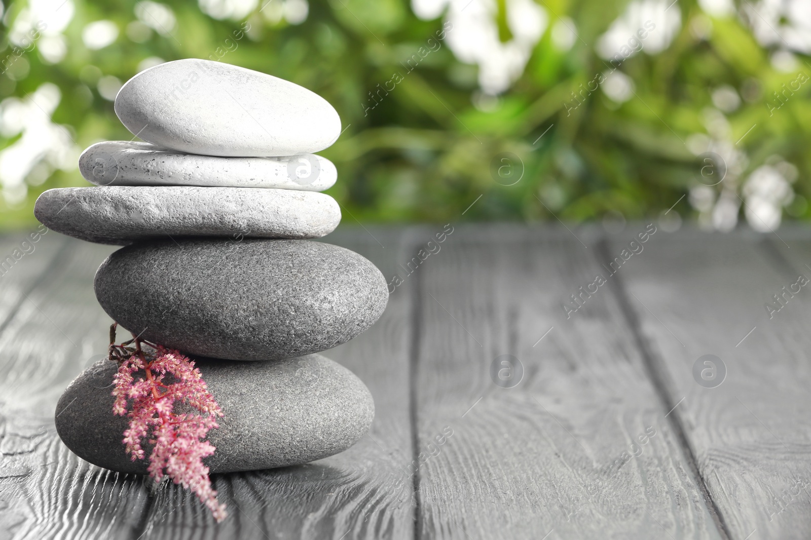 Photo of Spa stones on table against blurred background. Space for text