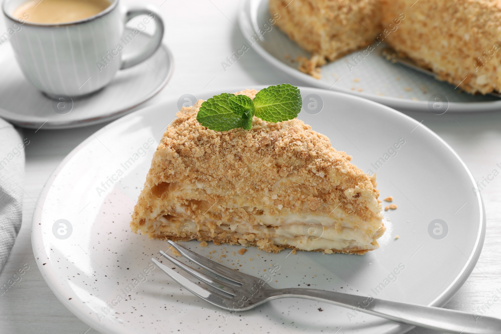 Photo of Piece of delicious Napoleon cake served on table, closeup