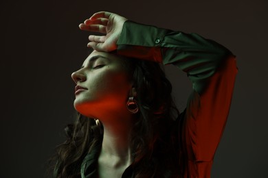 Portrait of beautiful young woman on dark background with neon lights