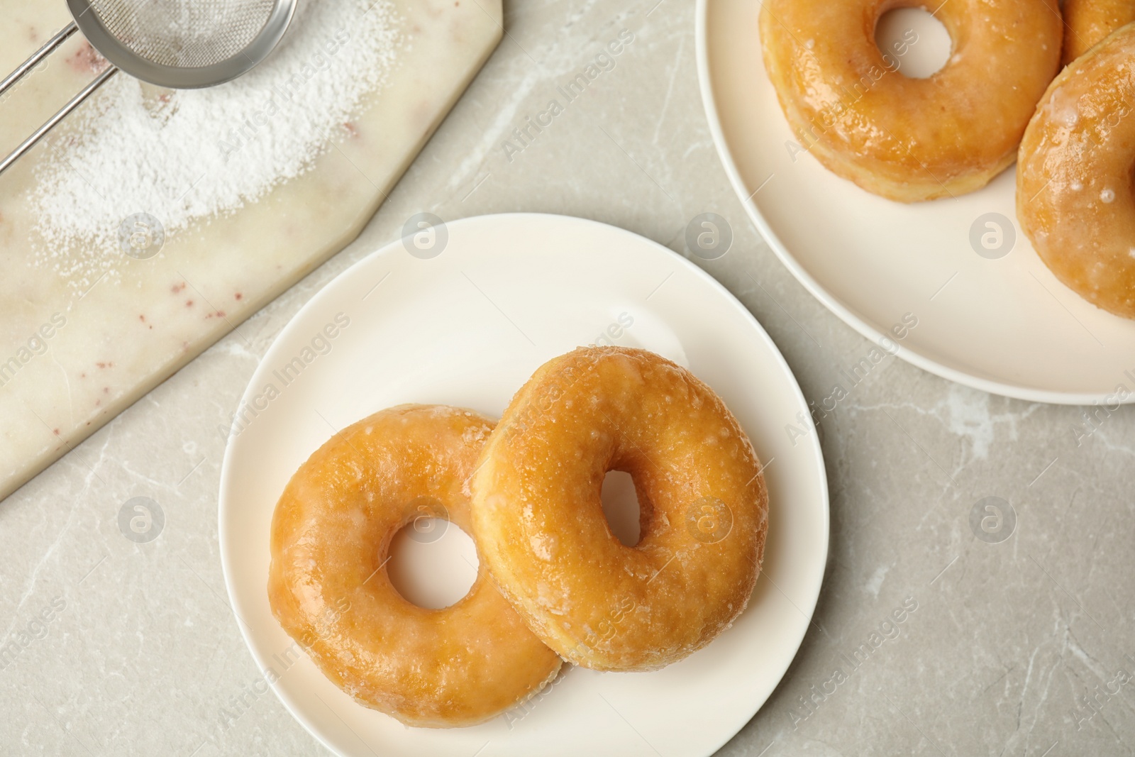 Photo of Delicious donuts on marble table, flat lay