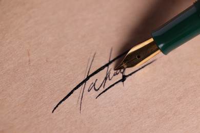 Photo of Signing on sheet of paper with fountain pen, closeup