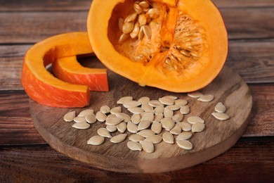 Fresh pumpkin and vegetable seeds on wooden table, closeup