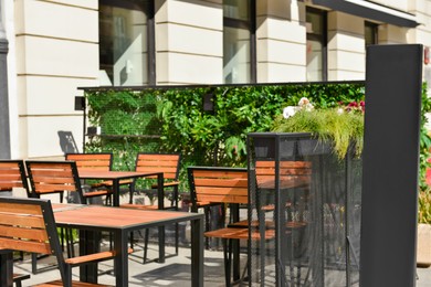 Photo of Empty chalkboard near outdoor cafe. Mockup for design