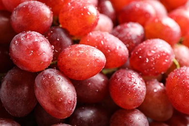 Fresh ripe juicy pink grapes as background, closeup view