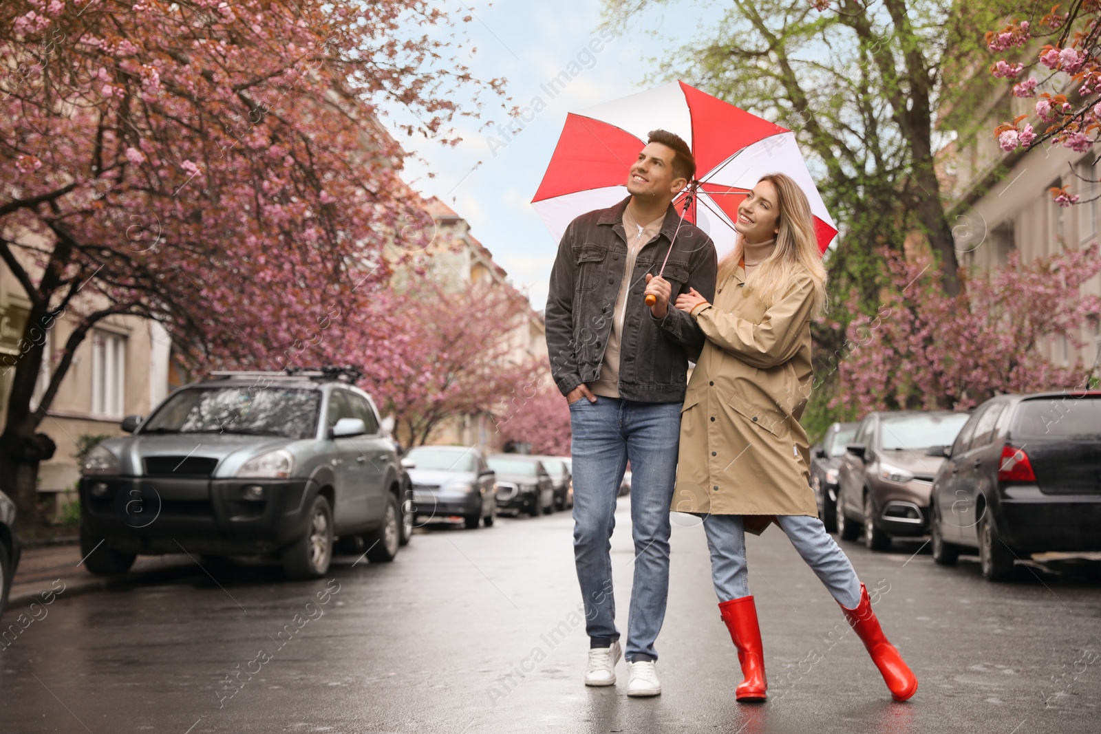 Photo of Lovely couple with umbrella walking on spring day