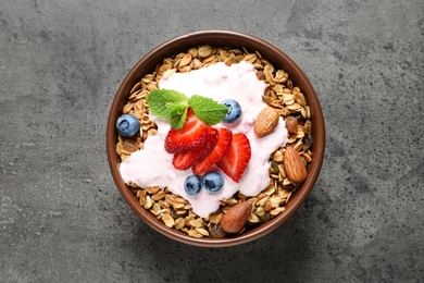 Photo of Delicious yogurt with granola and berries on grey table, top view
