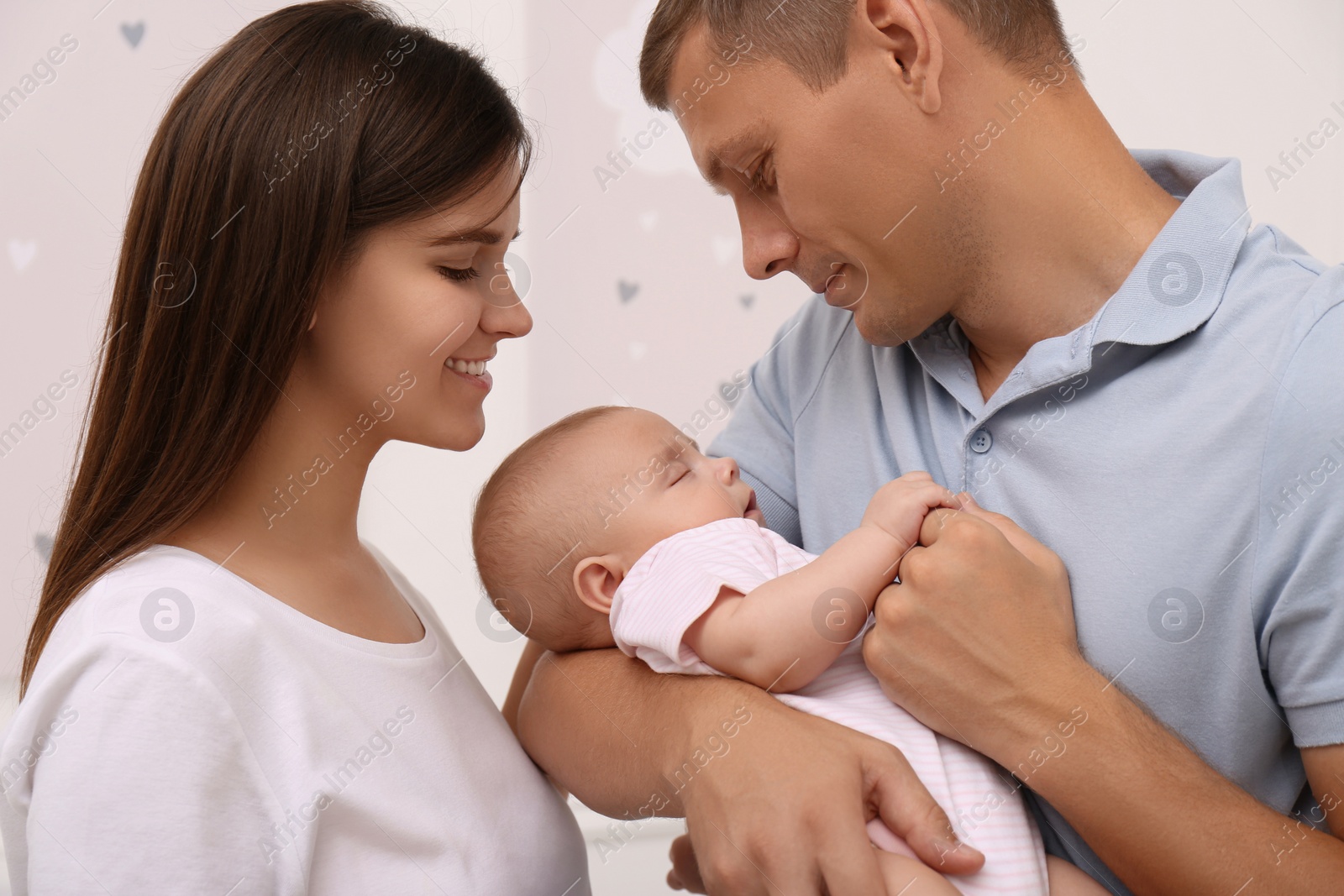 Photo of Happy family with their sleeping baby on blurred background