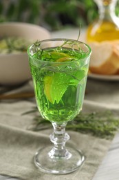 Photo of Delicious drink with tarragon in glass on white table