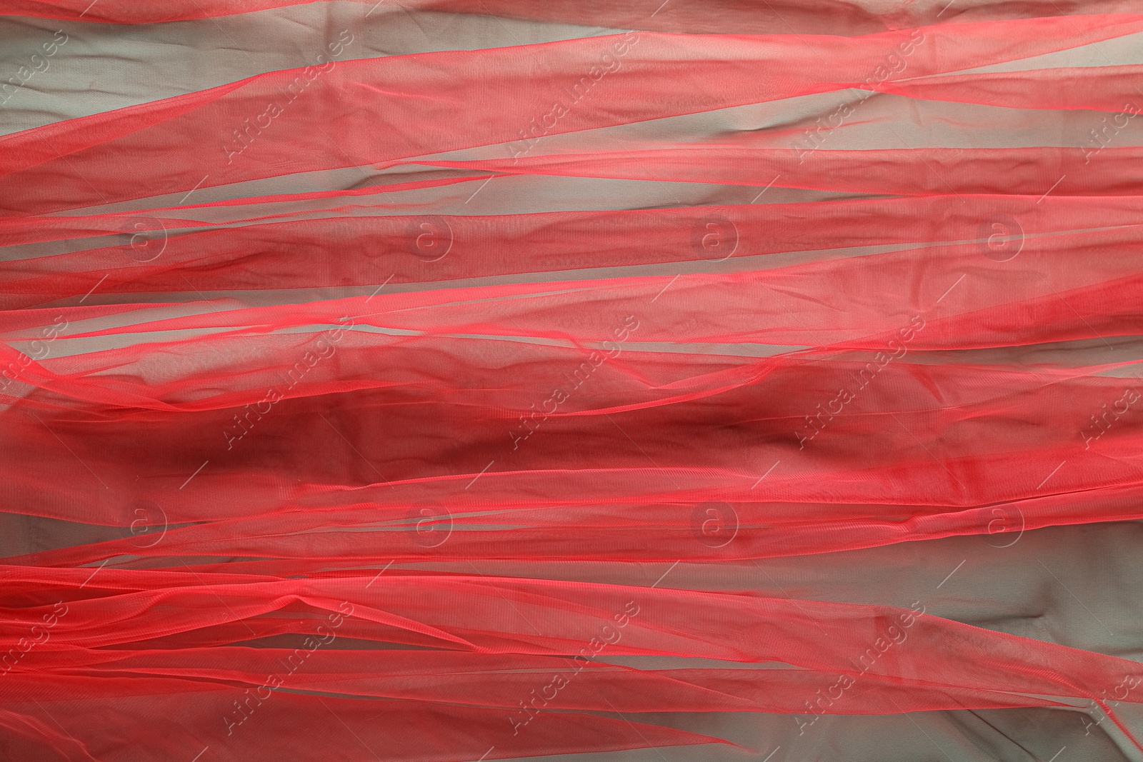 Photo of Beautiful red tulle fabric as background, top view