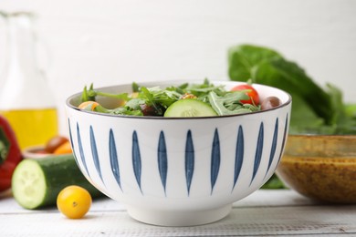 Photo of Tasty salad, vinegar based sauce (Vinaigrette) and products on wooden rustic table, closeup