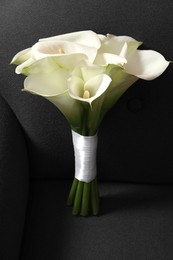 Beautiful calla lily flowers tied with ribbon on sofa