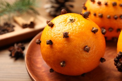 Pomander ball made of tangerines with cloves on wooden table, closeup