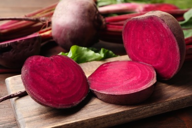 Cut raw beet on wooden board, closeup