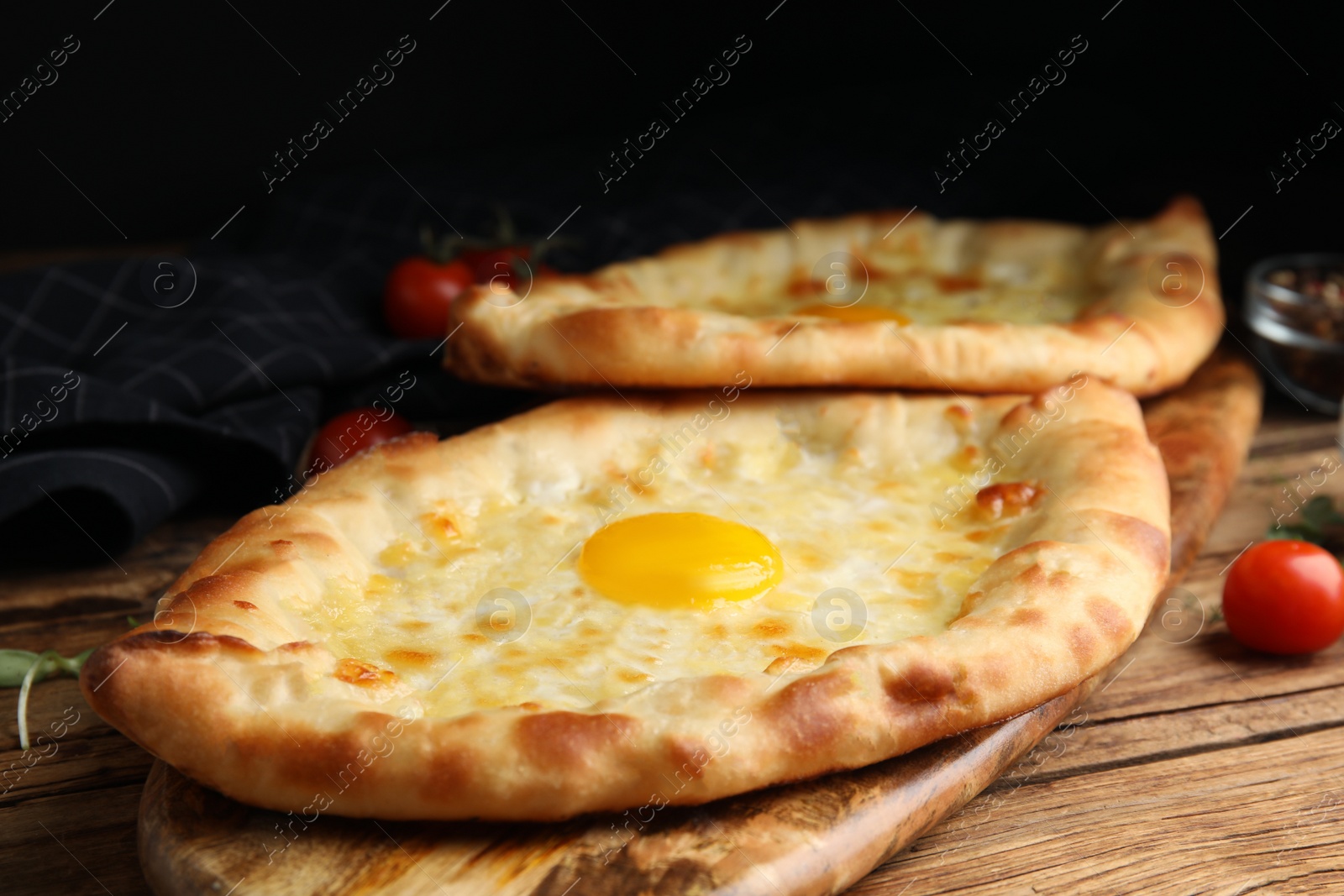 Photo of Fresh delicious Adjarian khachapuris served on wooden table