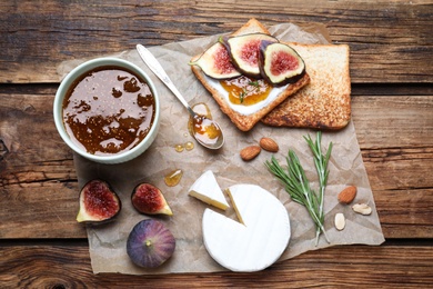 Photo of Flat lay composition with delicious fig jam on wooden table