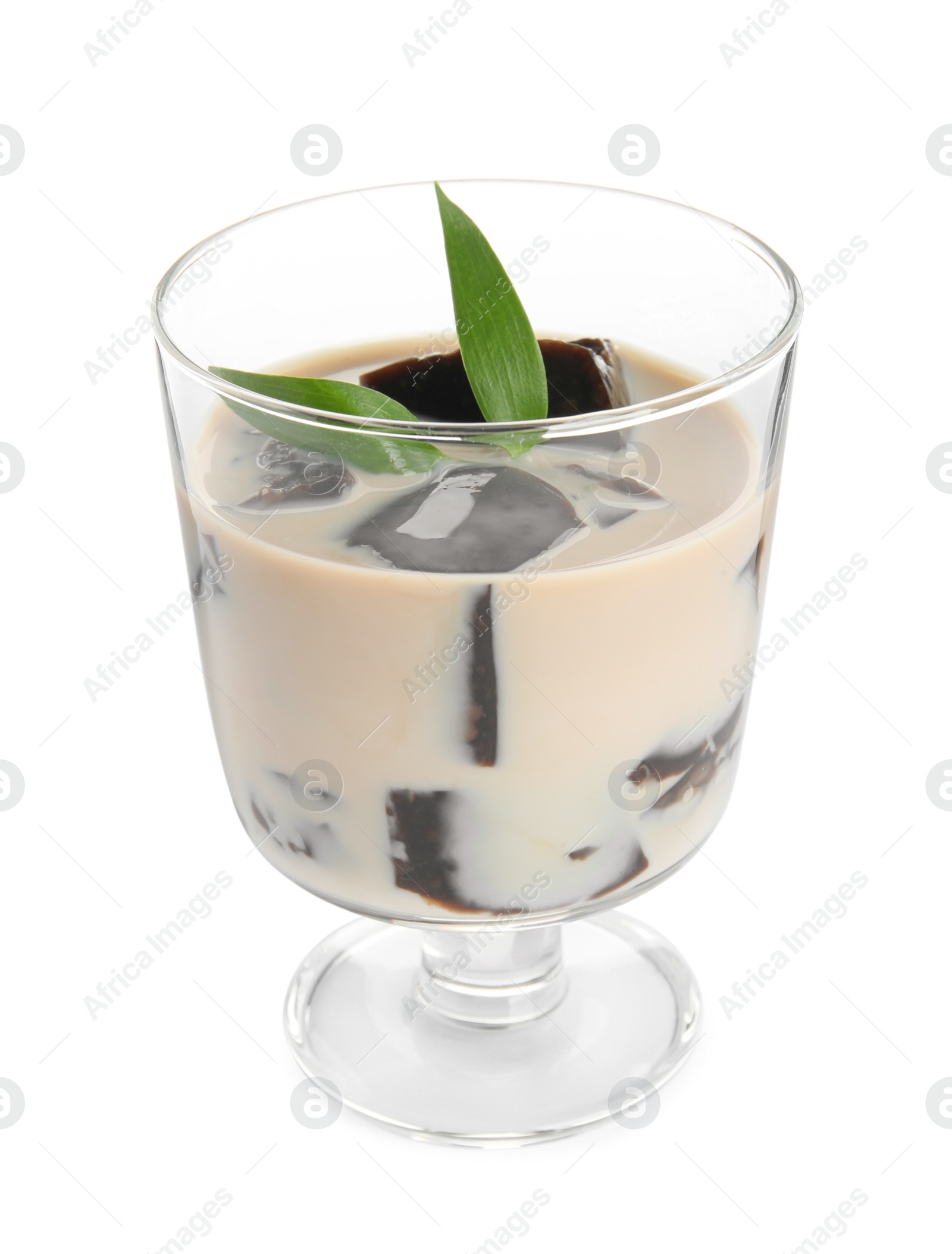 Photo of Glass of milk with grass jelly and green leaves isolated on white