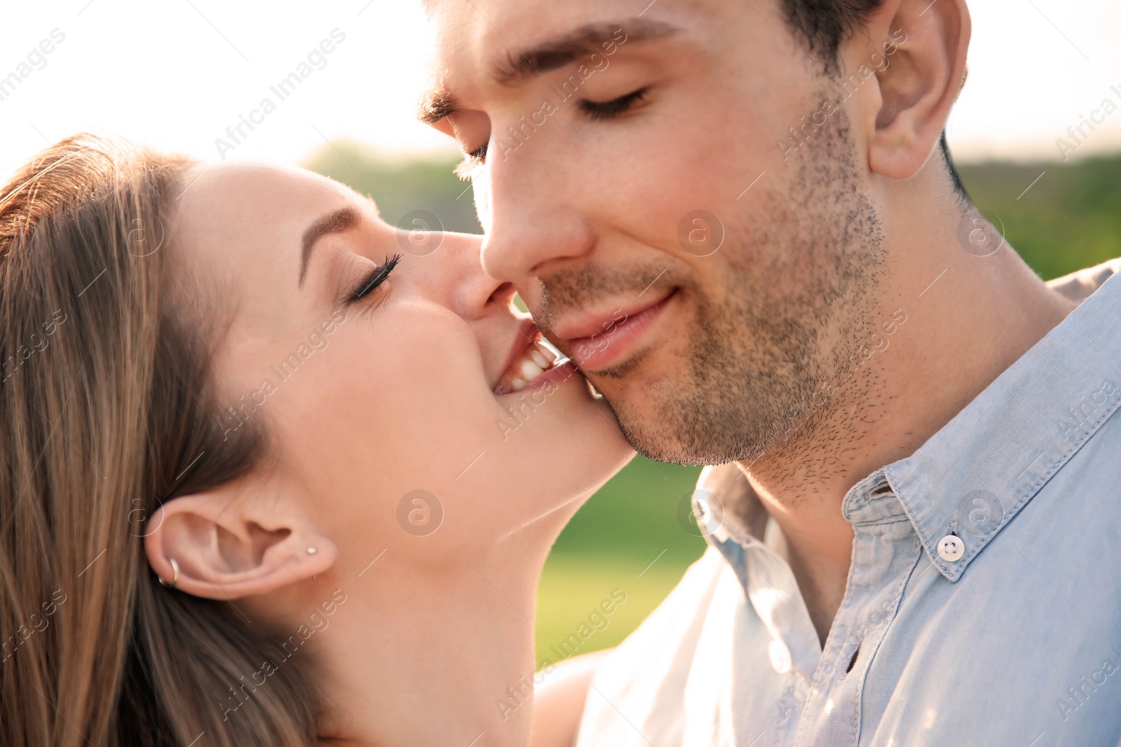 Photo of Cute young couple in love posing outdoors on sunny day