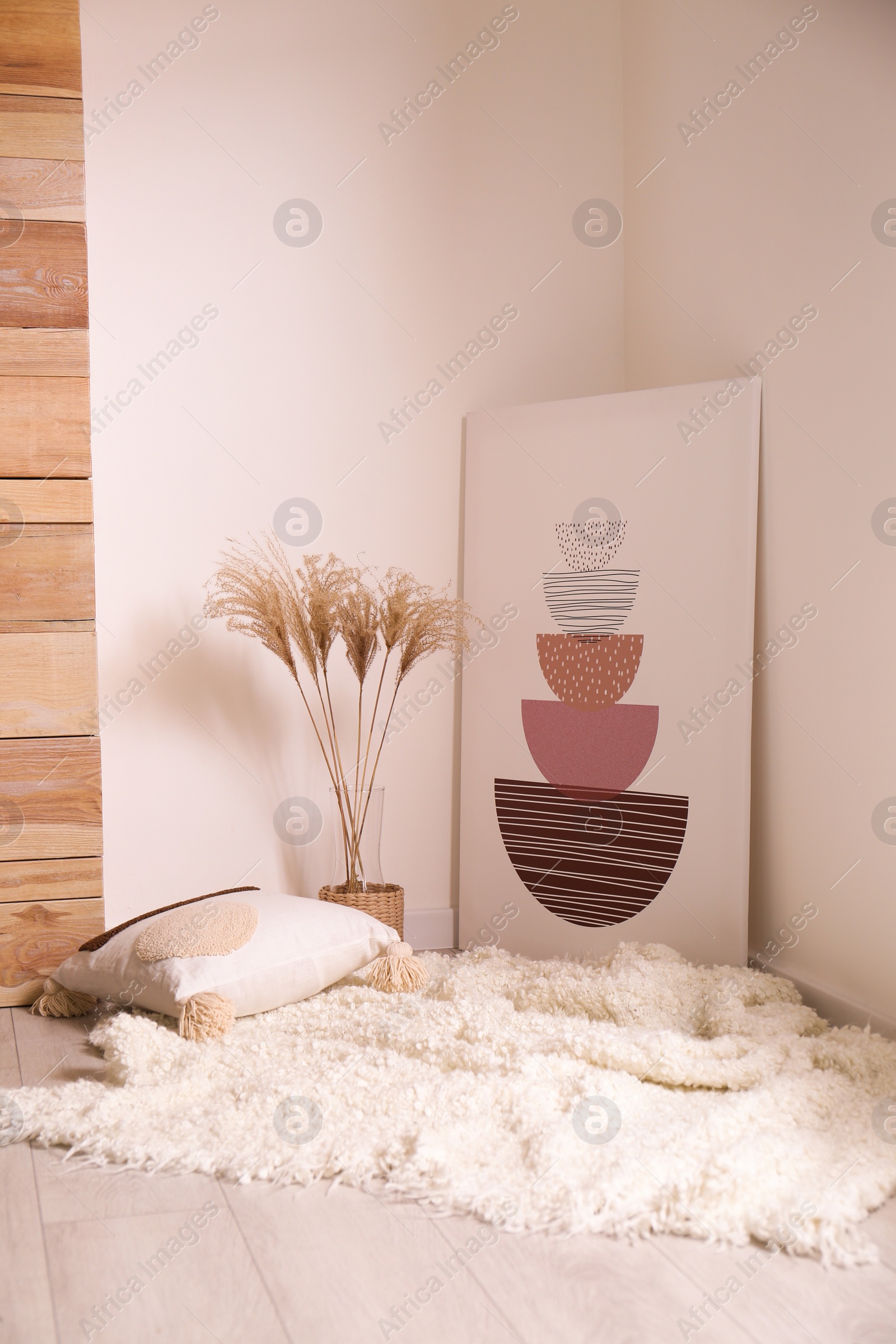 Photo of Vase with decorative dried plants and painting in stylish room interior