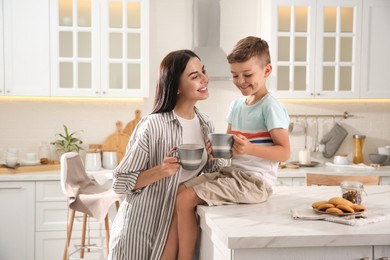 Happy mother and son having breakfast together in kitchen. Adoption concept