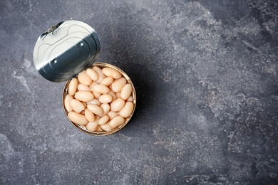Photo of Tin can with conserved beans on grey background, top view