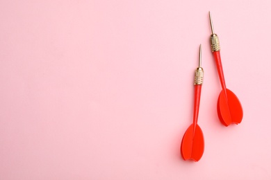 Photo of Red dart arrows on pink background, flat lay with space for text