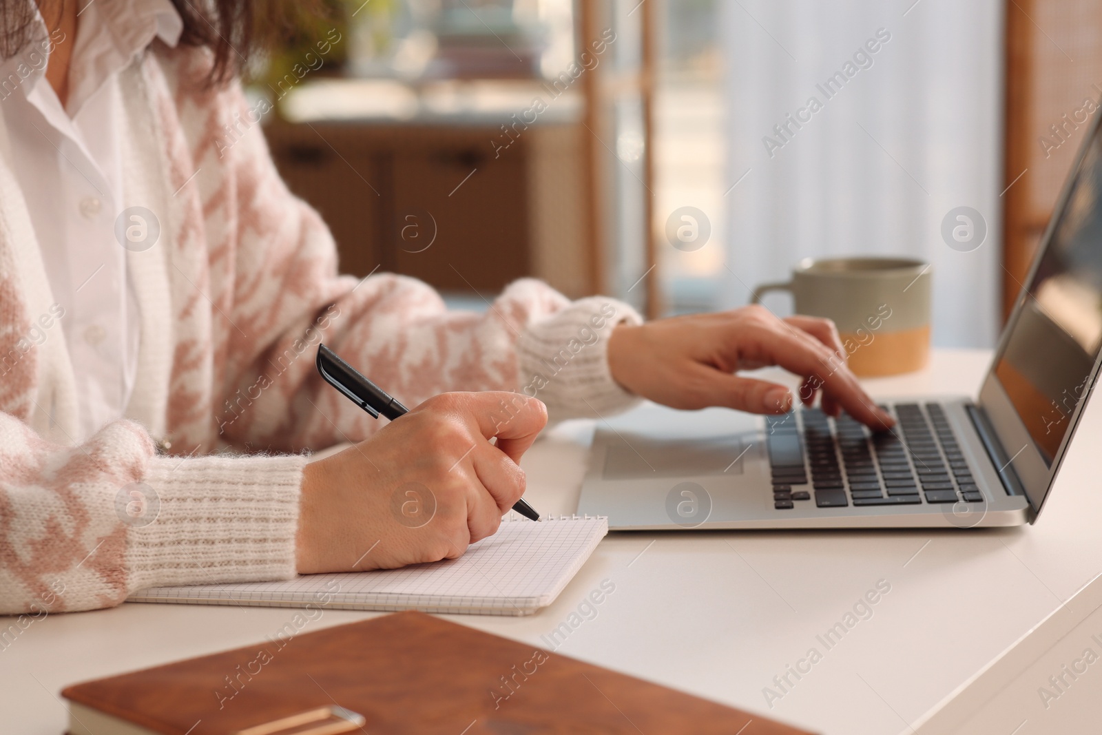 Photo of Woman with modern laptop learning at home, closeup