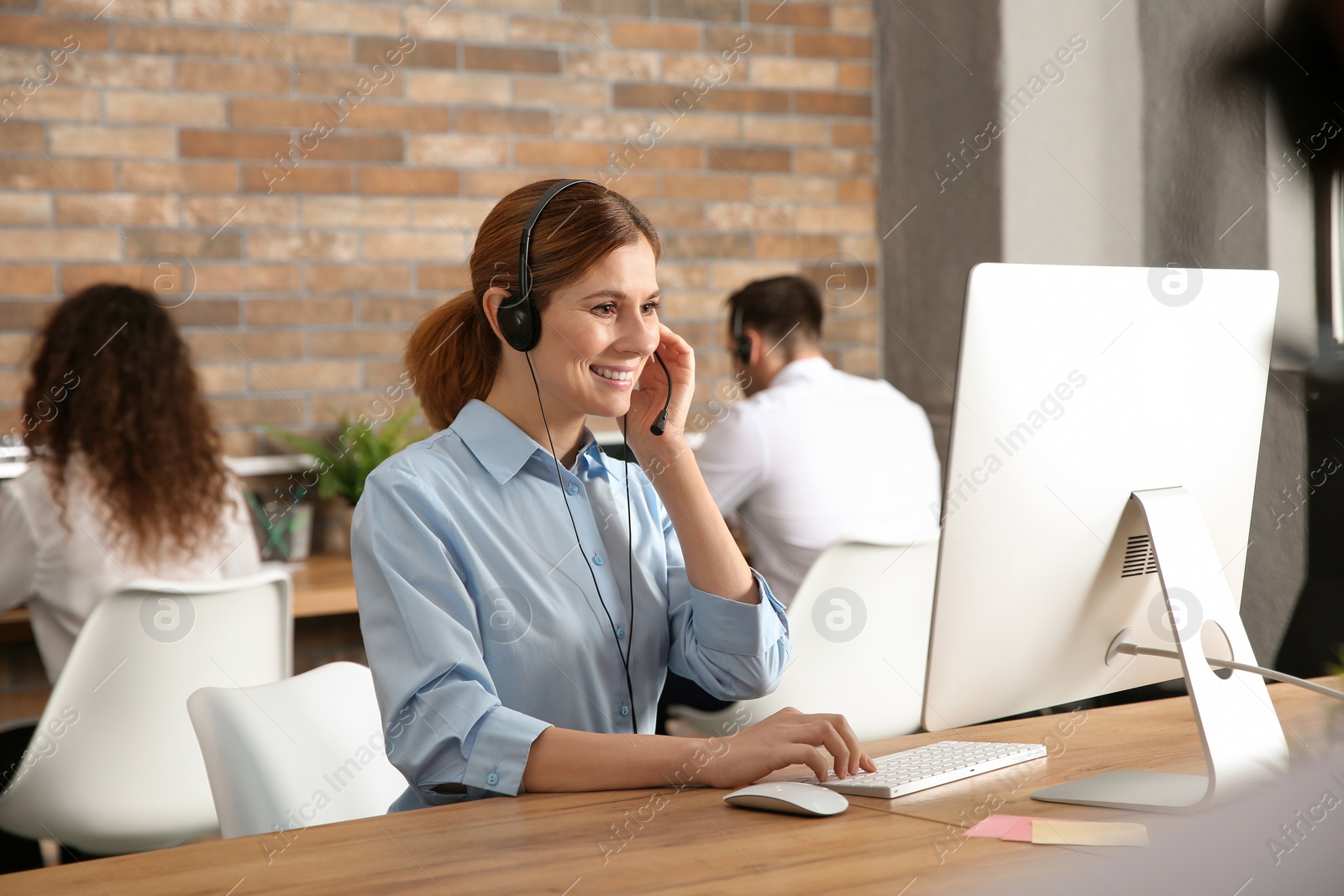 Photo of Technical support operator with headset at workplace