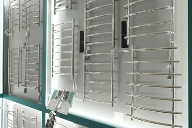 Assortment of modern heated towel rails in store