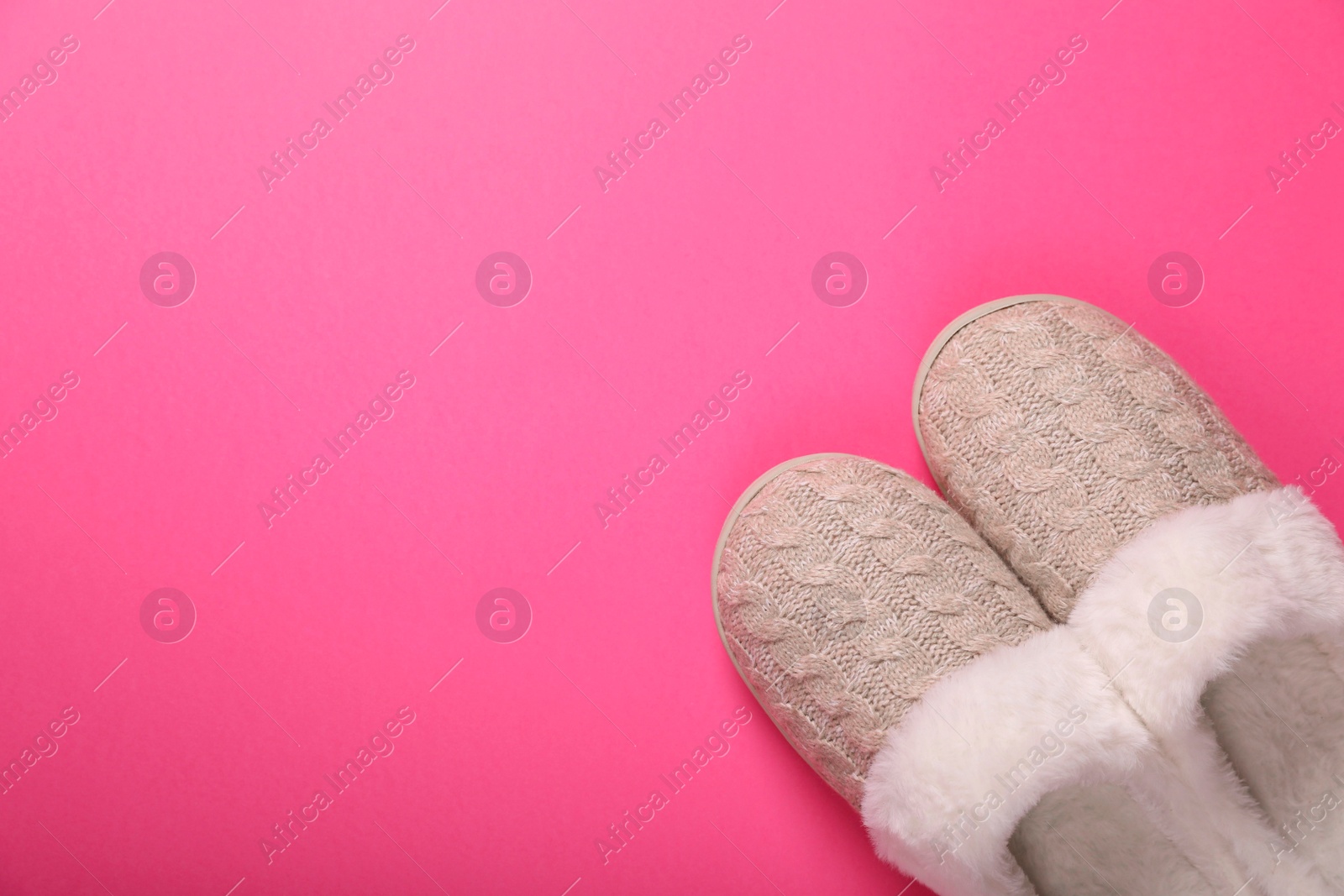 Photo of Pair of beautiful soft slippers on pink background, top view. Space for text