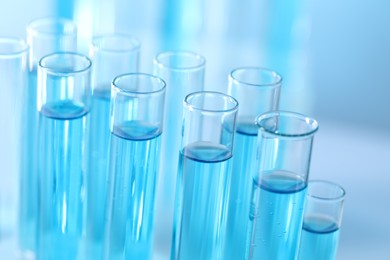 Photo of Test tubes with light blue liquid in laboratory, closeup