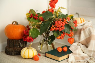Photo of Beautiful autumn composition with different pumpkins and book indoors