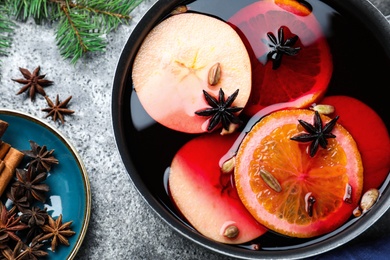 Delicious mulled wine and ingredients on grey table, flat lay