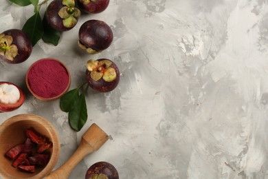 Photo of Purple mangosteen powder and fruits on light grey table, flat lay. Space for text