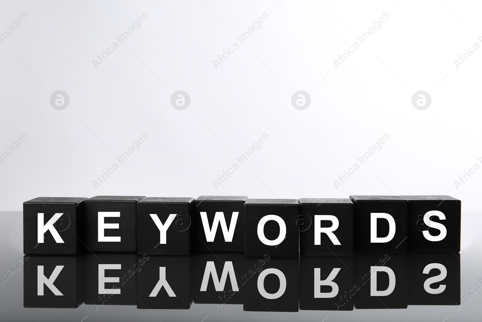 Photo of Black cubes with word KEYWORDS on white background