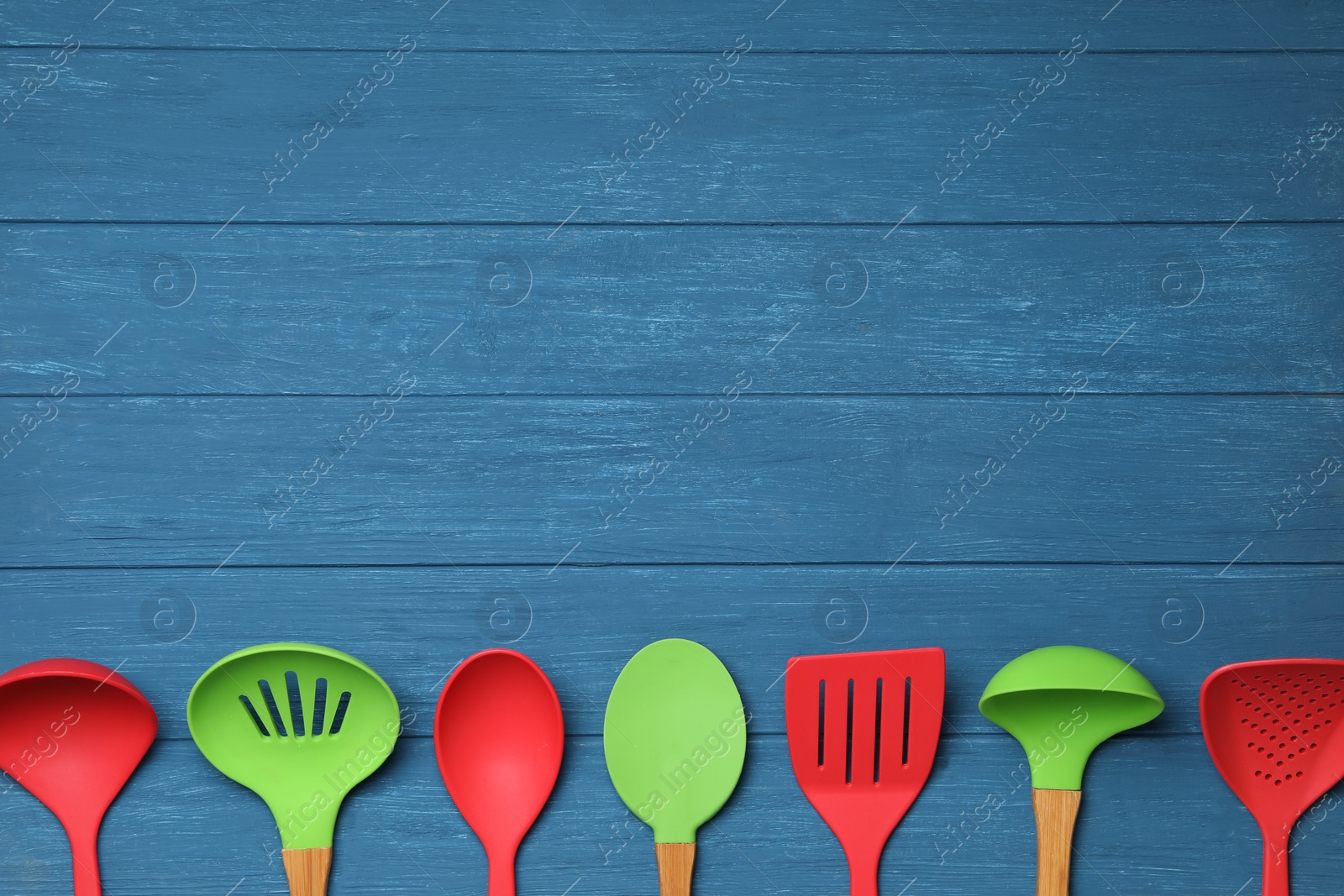 Photo of Set of modern cooking utensils on blue wooden table, flat lay. Space for text