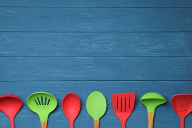 Set of modern cooking utensils on blue wooden table, flat lay. Space for text