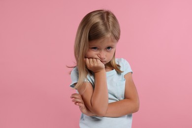 Photo of Portrait of resentful little girl on pink background