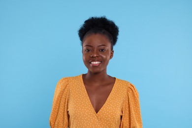 Photo of Portrait of beautiful young woman on light blue background