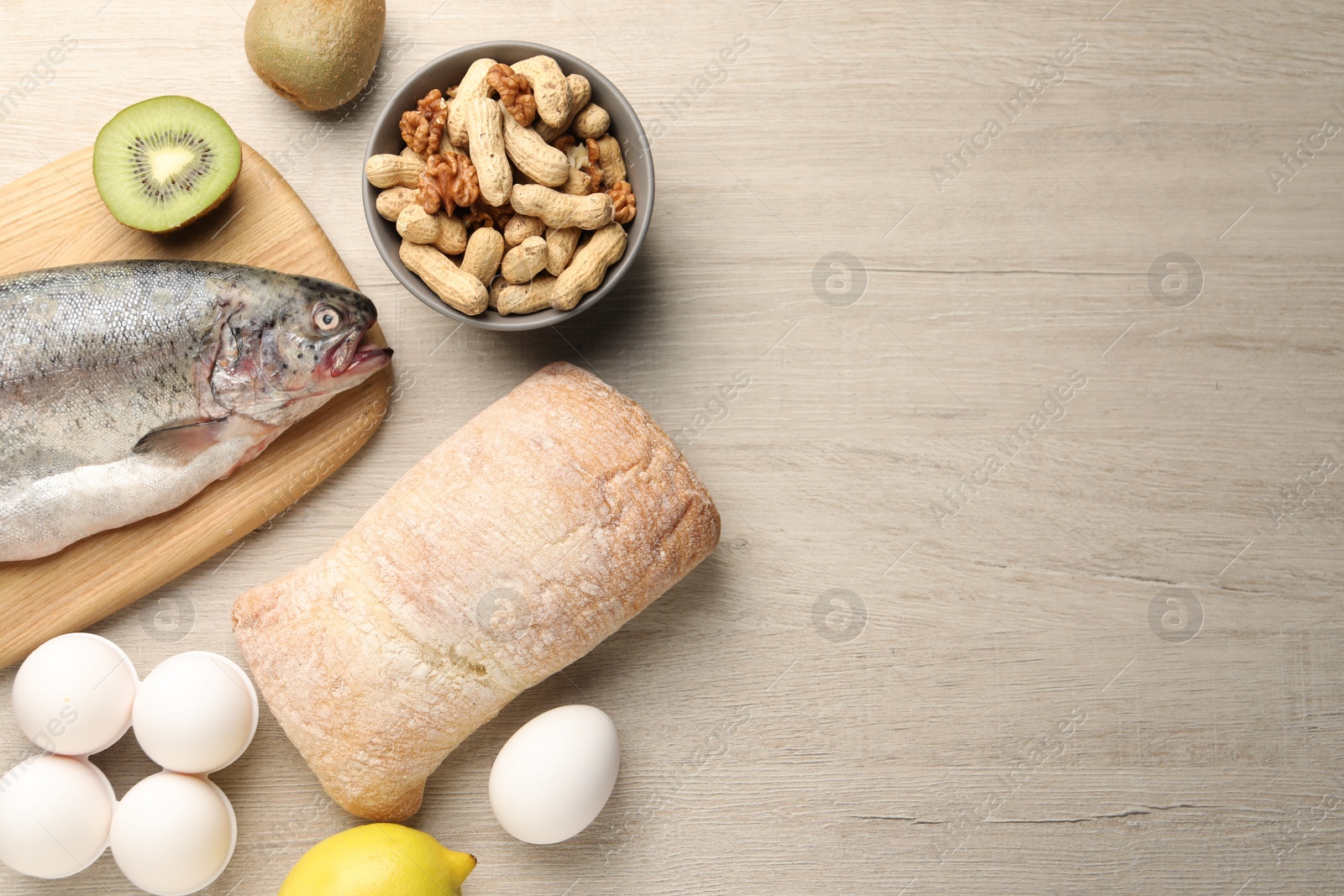 Photo of Allergenic food. Different fresh products on wooden table, flat lay and space for text